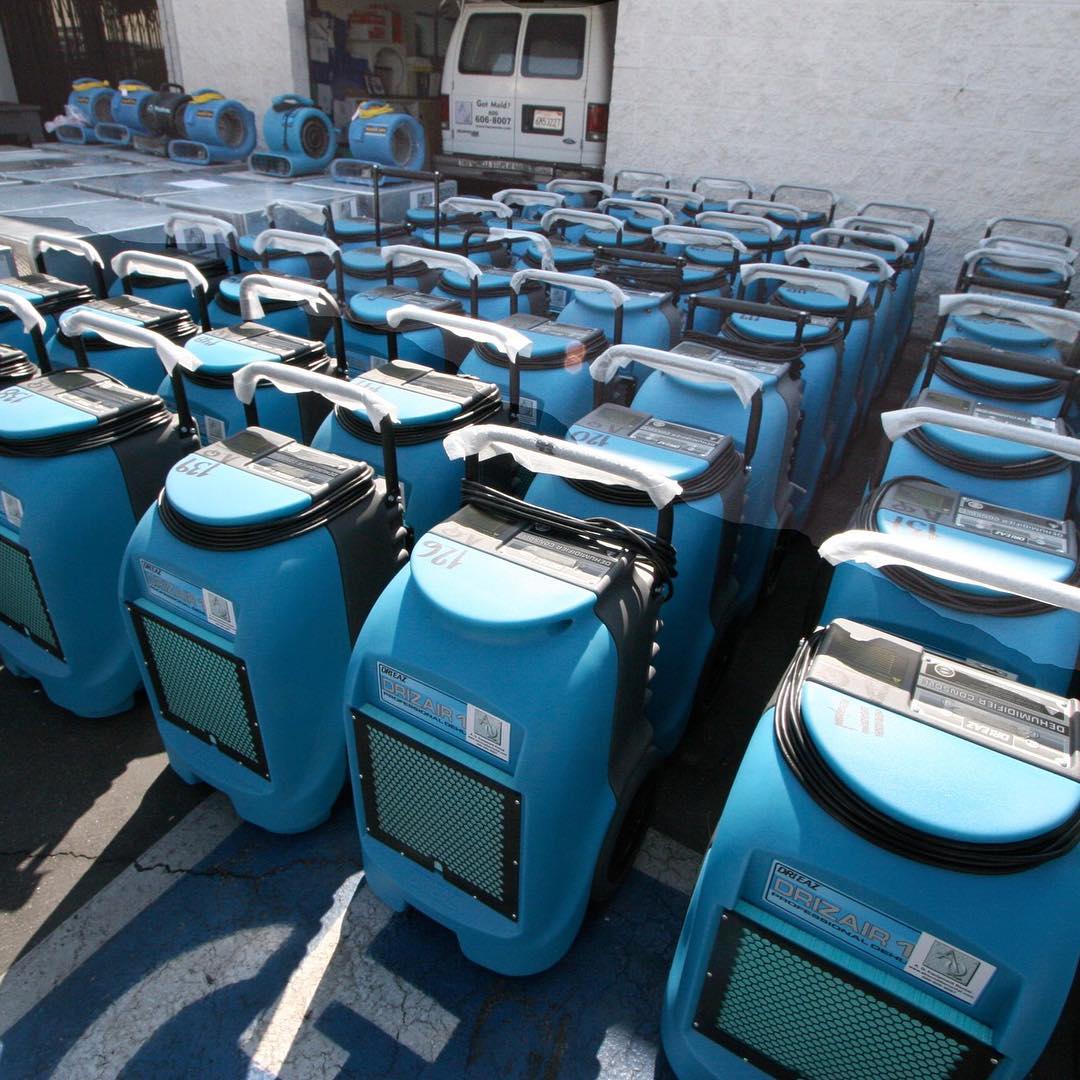 Row of blue industrial air dryers lined up outside a service vehicle