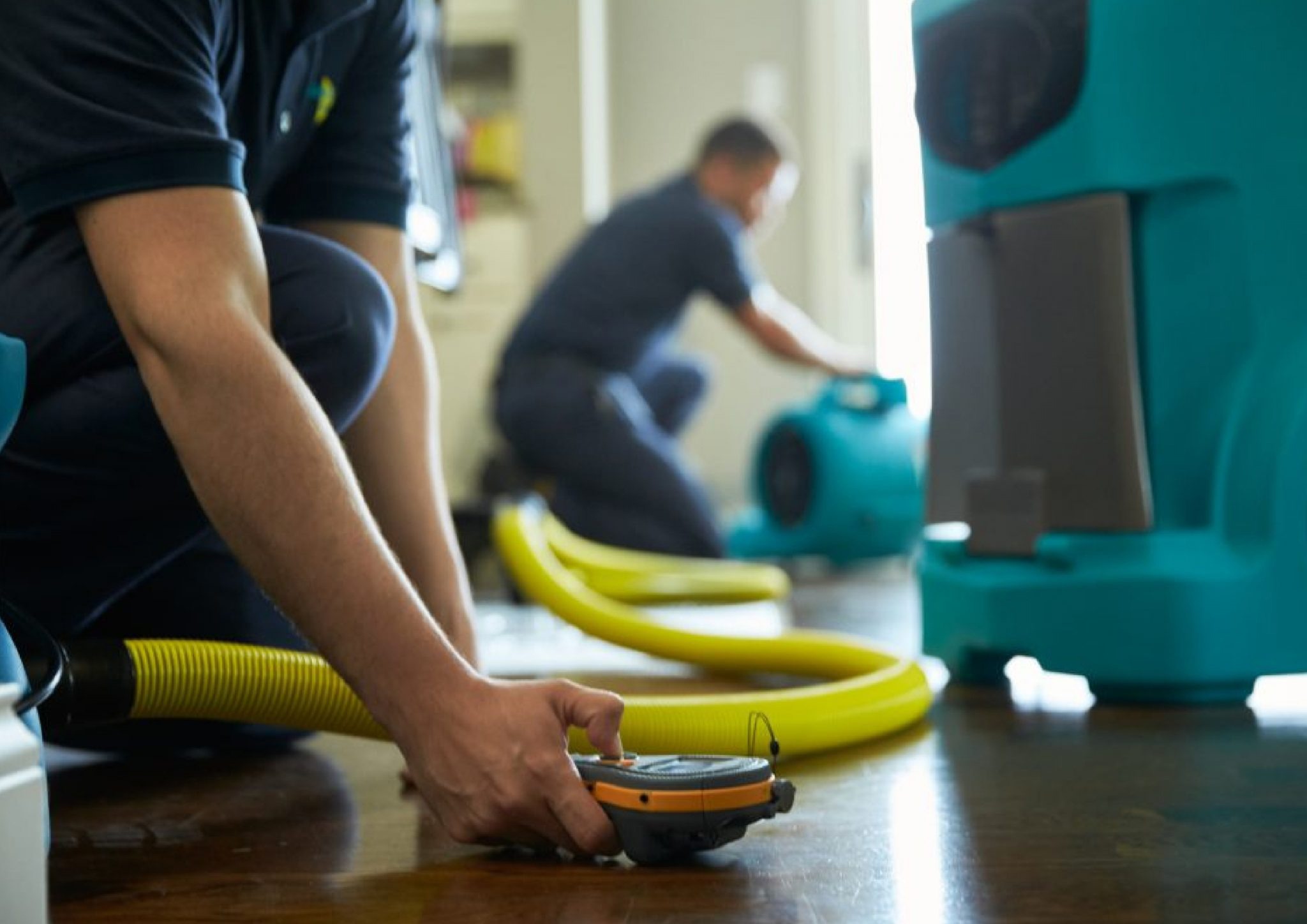 Water damage restoration professionals set up drying equipment,