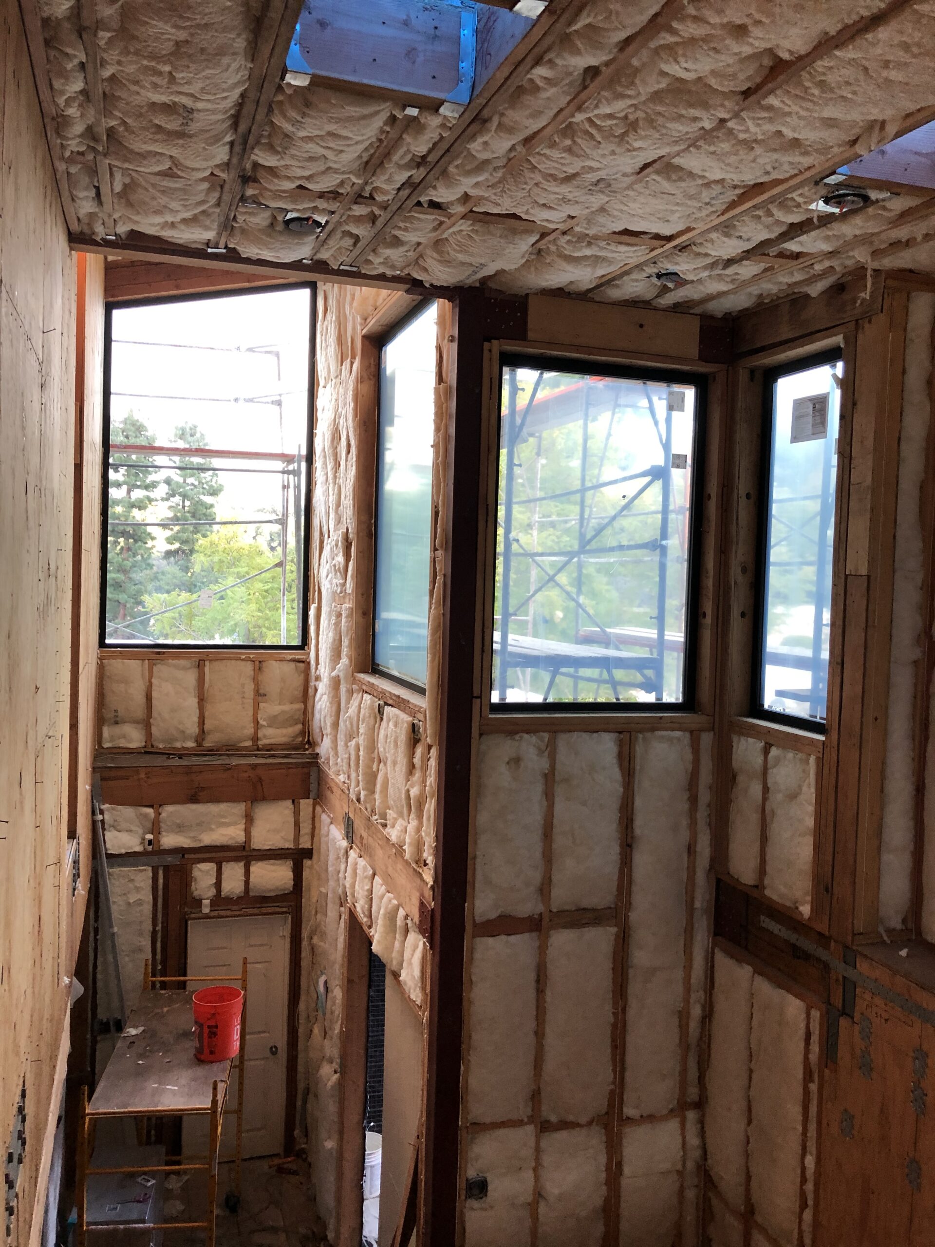 Interior shot of a construction site featuring insulated walls and large windows.